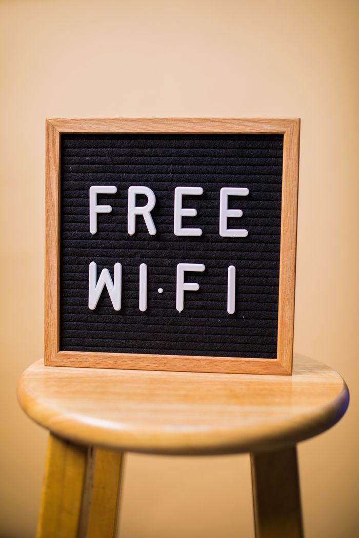 services-04 Letterboard displaying 'Free Wi-Fi' on a wooden stool in an indoor setting.